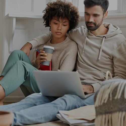 couple relaxing together looking at laptop